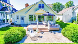 A two-story house with a covered patio, a front door, and a garage. - Lakefront sunsets, dock fishing & cozy fire · 20 min to Mad River (Belle Center)