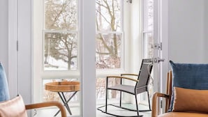 A room with a sliding glass door leading to a balcony with two chairs and a small table. - Sleeps 12, Firepit, near Downtown/SU (Syracuse)