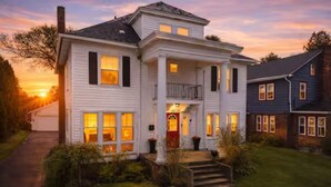 A two-story house with a front porch, a visible garage, and a well-maintained lawn. - Sleeps 12, Firepit, near Downtown/SU (Syracuse)
