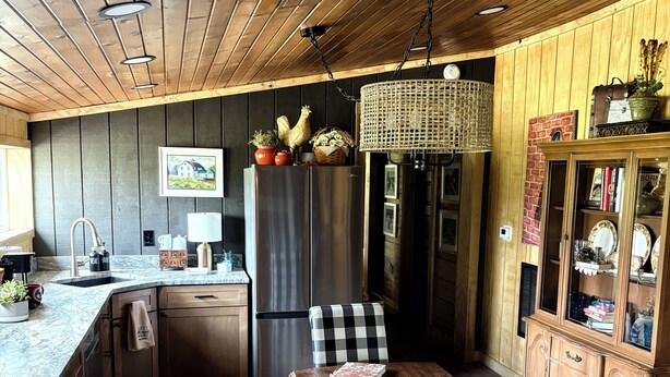 A wooden interior with a kitchen, dining area, and a cabinet with glass doors. - Working Horse Ranch Retreat – 2 Bedrooms, Fire Pit, 20 Min to Downtown Nashville (Goodlettsville)