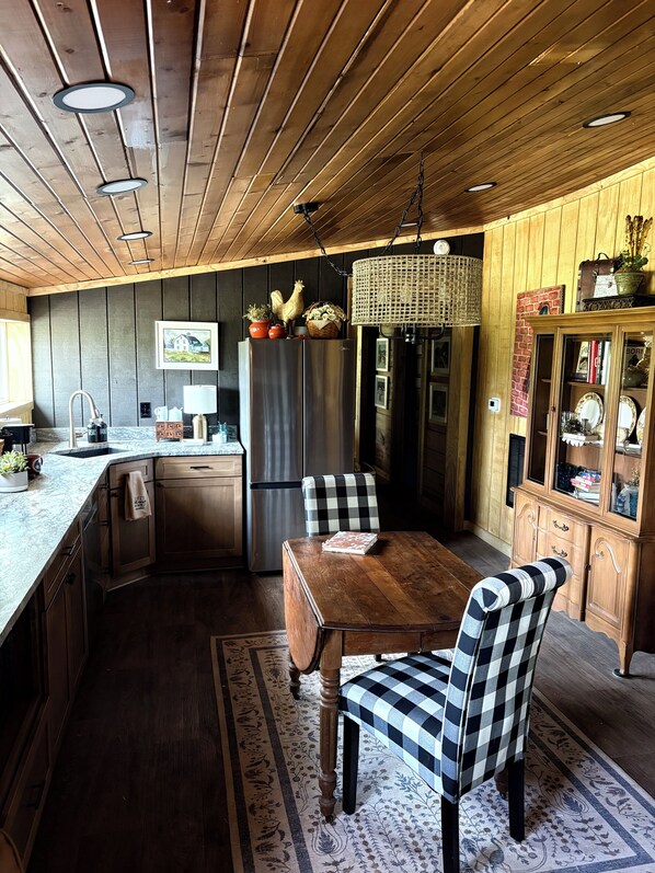 Un intérieur en bois comprenant une cuisine, un coin repas et un meuble avec des portes en verre.