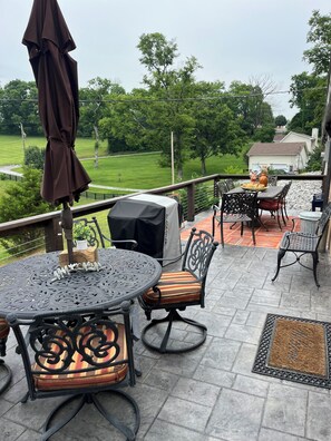 A patio with outdoor furniture, a grill, and a view of a green landscape. - Working Horse Ranch Retreat – 2 Bedrooms, Fire Pit, 20 Min to Downtown Nashville (Goodlettsville)