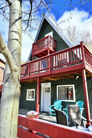 A two-story cabin with a balcony, a door labeled '22600', and outdoor seating. - Delightful 3-bedroom chalet in charming Salida perfect for getaway (Salida)