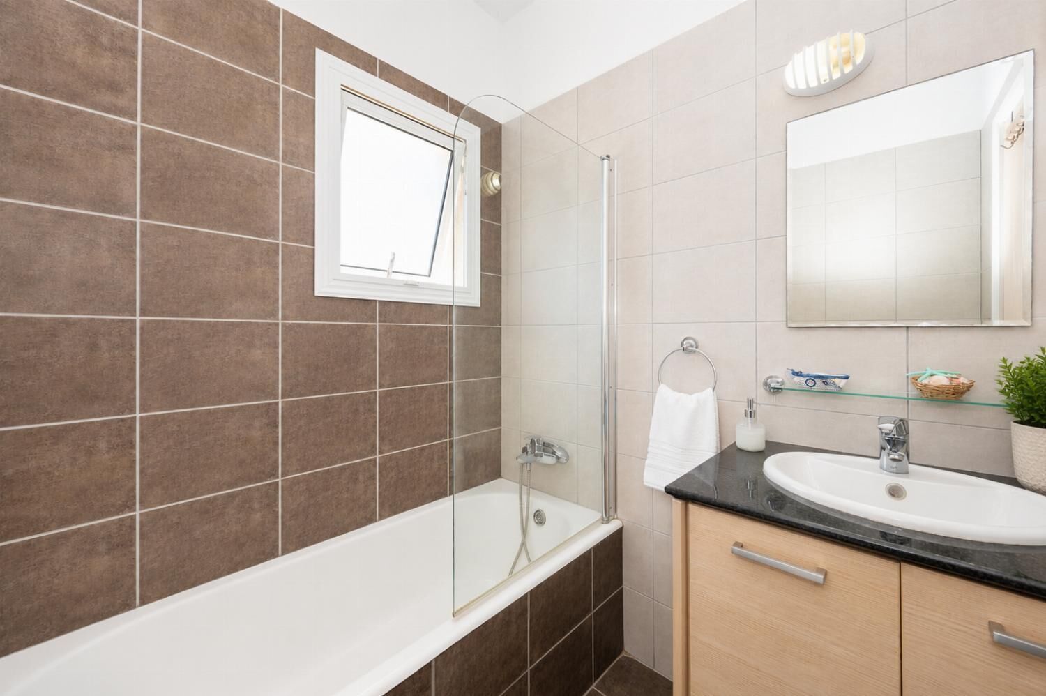 Une salle de bain moderne avec une baignoire, une douche à l’italienne avec des parois en verre, un meuble-lavabo et un grand miroir.