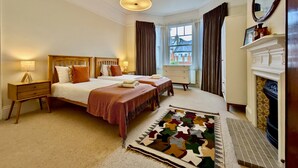 A hotel room with two beds, a fireplace, a large window, and a view of the outside. - Stunning Family Home in Tulse Hill (London)