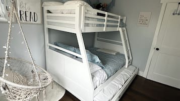 Ein Stockbett mit Hängesessel, eine weiße Tür und motivierende Wandbilder.