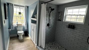 Un baño con ducha, inodoro y lavabo.