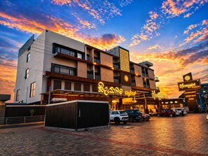 A hotel with a modern facade, a signboard for Hemagiri Palace, and a paved entrance area. - Hemagiri Palace (Devanahalli)