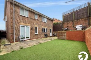 A two-story brick house with a small backyard, a patio, and a fenced area. - 5 Bed with superfast Wifi for short and long stay (Chatham)