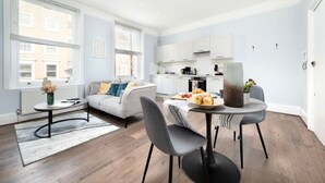 A modern apartment with a dining area, kitchen, and living space. - Serene One-Bedroom Retreat in Fitzrovia (London)