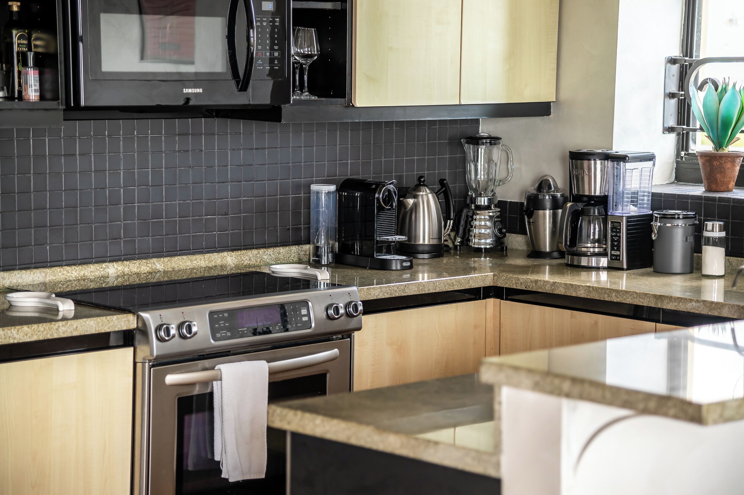 A kitchen with a microwave, stove, and various appliances like a coffee maker and blender.
