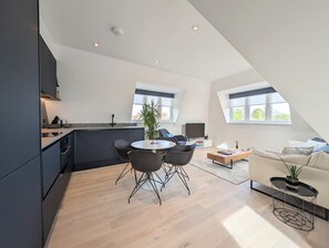 A modern loft apartment with a kitchen, dining area, and living space. - Modern Apartment in Moss Hall Court (London)