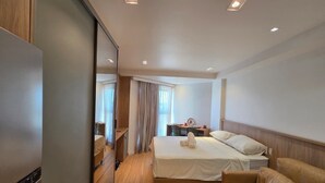 Une chambre d’hôtel avec un lit, un canapé, un bureau et un miroir.