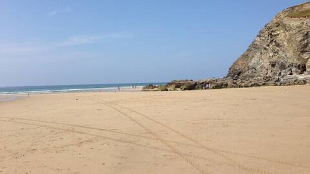 A sandy beach with a rocky cliff and the ocean in the background. - Spacious Home Near Porthtowan Beach (Porthtowan)