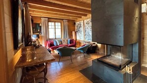 A cozy interior with a fireplace, wooden furniture, and a dining area. - -La Rosière- Premium Chalet, in the center of Villars-sur-Ollon (Villars-sur-Ollon)