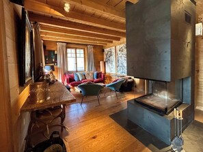 Ein gemütliches Interieur mit Kamin, Holzmöbeln und einem Essbereich.