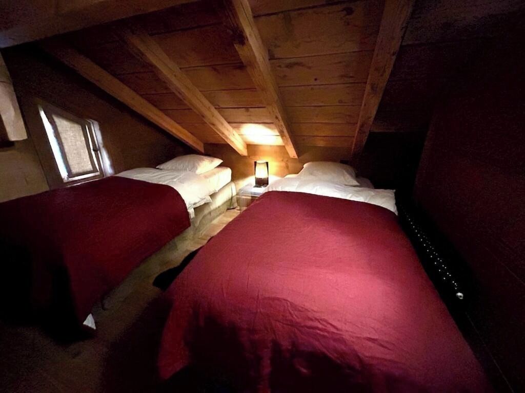 Une chambre individuelle avec deux lits, une table de chevet et une fenêtre.