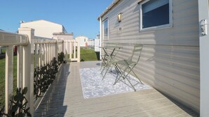 Une rangée de maisons mobiles dotées d’une terrasse en bois et d’un étendoir.