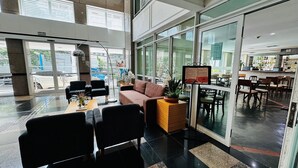 A spacious lobby with a seating area, a reception desk, and a view of the outside. - HOTEL PERDIZES - Flat Executivo - 1402 (São Paulo)