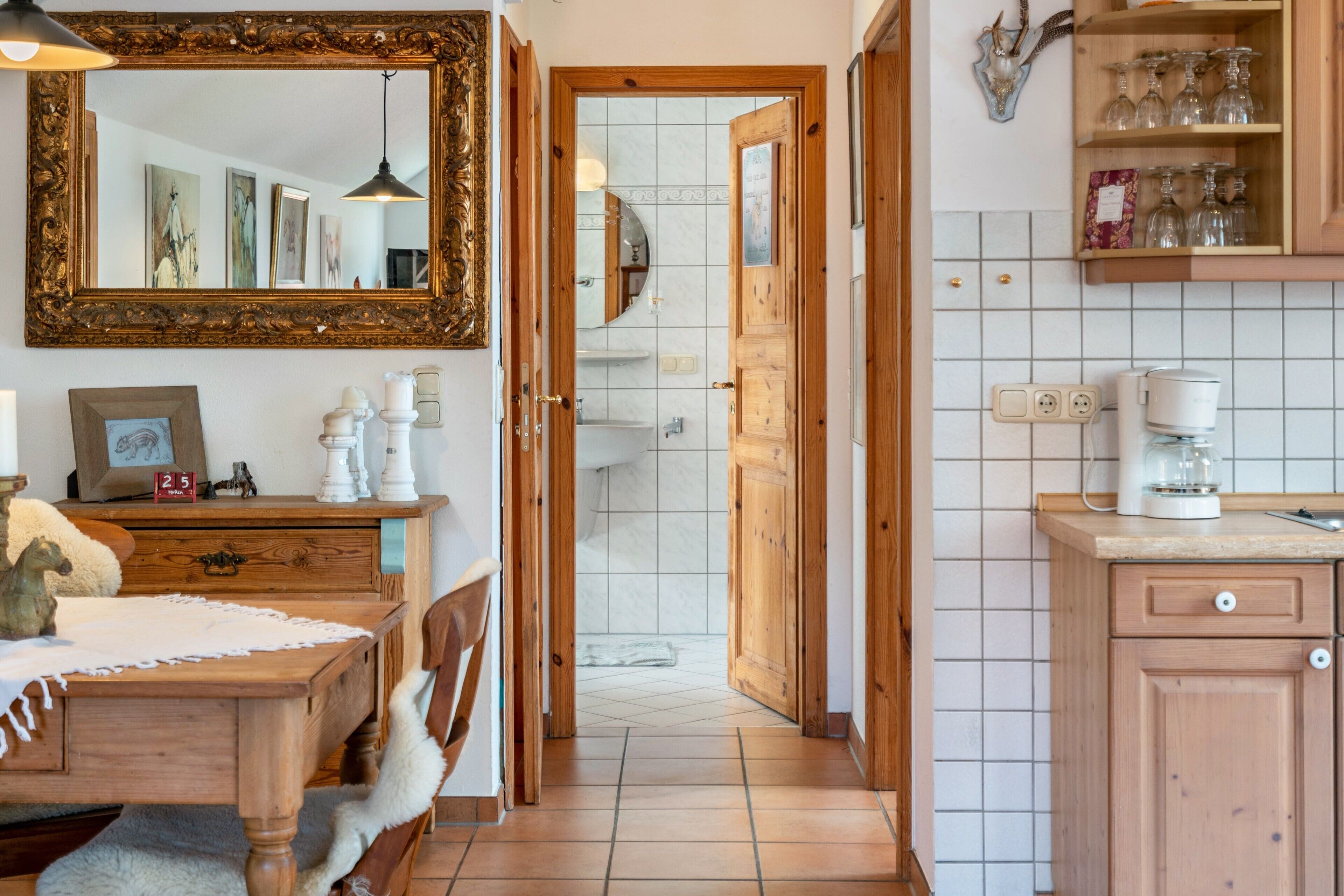 A kitchen with wooden cabinets, a coffee maker, and a tiled backsplash.