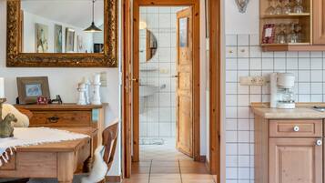 A kitchen with wooden cabinets, a coffee maker, and a tiled backsplash.
