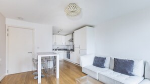 A modern apartment with a dining area, kitchen, and living room. - Modern King’s Cross Central Apartment (London)