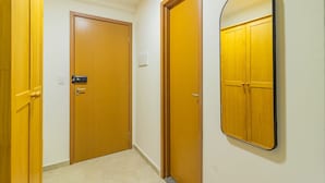 A hallway with wooden doors and a wall-mounted mirror. - Cupe Suites #118 Beachfront by Carpediem (Ipojuca)