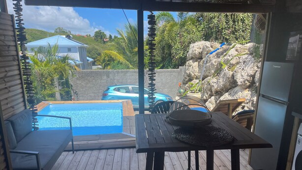 A wooden deck with a pool, a table with a woven basket, and a chair.
