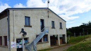 A building with a staircase, a horse sculpture, and a signboard. - Modern apartment with country view - 2 guests (Le Vernet)