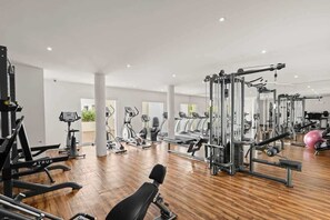 A modern gym with various exercise equipment, including treadmills, ellipticals, and weight machines. - 2BR Downtown Cabo Walk to Beach & Dining (Cabo San Lucas)
