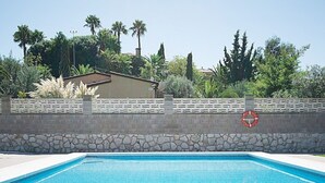 Ein Schwimmbad mit Steinmauer und Rettungsring.