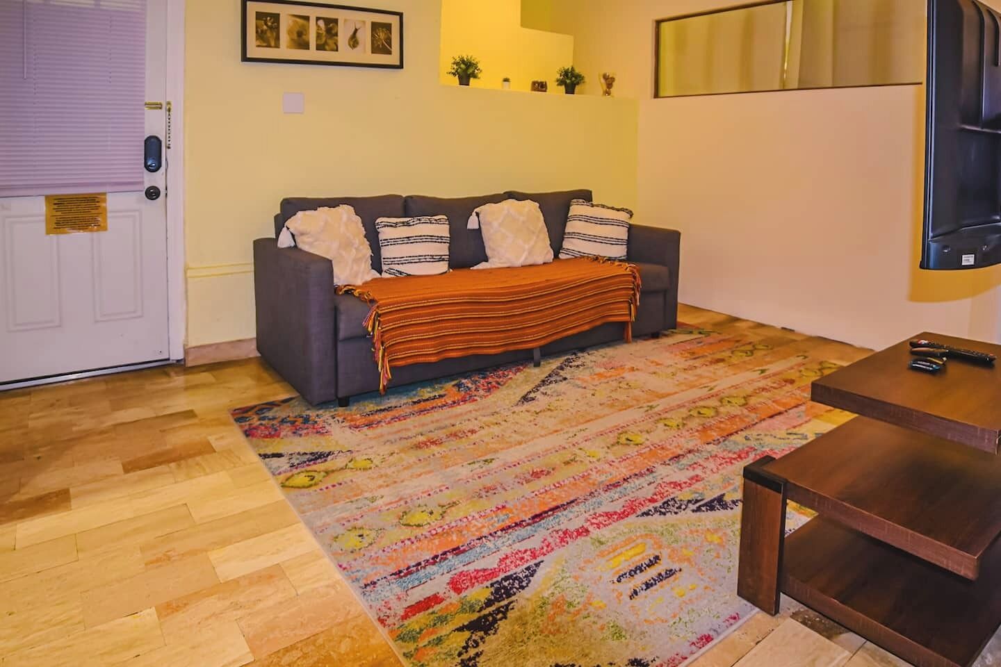 Spacious living room with bohemian touches and wooden floors, ideal for unwinding after exploring the city. Perfect for solo travelers seeking a peaceful corner.