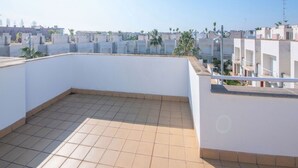 A rooftop terrace with tiled flooring, white walls, and a clear view of surrounding buildings and palm trees. - Modern house in Altafulla, near beach, 6 people (Altafulla)