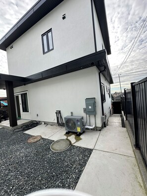 A modern two-story building with a flat roof and a large air conditioning unit on the ground floor. - BRAND NEW MODERN 3BR LANEWAY HOUSE (Vancouver)