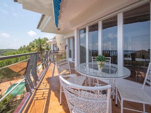 A balcony with a glass table and white chairs, overlooking a pool and greenery. - Spacious villa in La Mora, 4 bedrooms, near the beach (Tamarit)