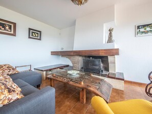 A living room with a fireplace, a sofa, a coffee table, and a chair. - Spacious villa in La Mora, 4 bedrooms, near the beach (Tamarit)