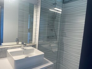 A bathroom with a white sink, a mirror, and a glass shower enclosure. - Cozy studio, AC and parking - 2 guests in La Grande-Motte (La Grande-Motte)