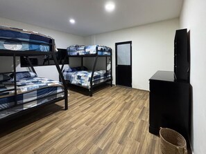 Una habitación con literas, televisión y escritorio.