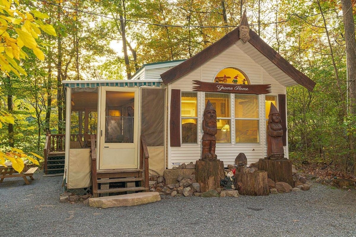 A small cabin-style building with a porch, a door, and a sign that reads 'Gnome Home.'