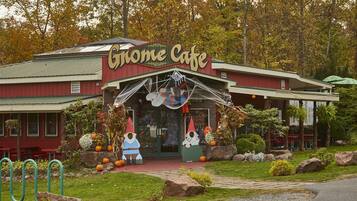 Un edificio con un letrero que dice 'Gnome Cafe' y un porche decorado con adornos de Halloween.