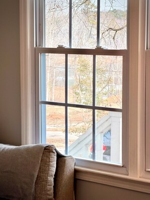 Ein Fenster mit Blick auf Bäume und ein Gebäude.