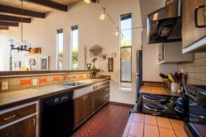 Una cocina con armarios de madera, lavavajillas, estufa y fregadero.