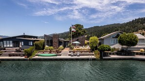 Um imóvel à beira-mar com piscina, espreguiçadeiras e um mastro.
