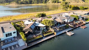 Een woongebied aan het meer met moderne huizen, een steiger en een boot.