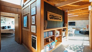 Een gezellige, goed verlichte kamer met een houten boekenkast, een televisie en een kamerbreed tapijt met een patroon.
