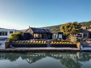 A modern house with a pool, surrounded by landscaped gardens and a view of hills.