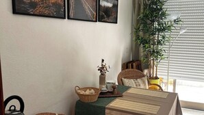 En hyggelig stue med sofa, bord, dekorativ statue og en potteplante.