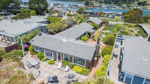 Vue aérienne d’un quartier résidentiel avec des maisons, une terrasse dotée de mobilier d’extérieur et une vue sur un lac.