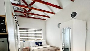 Ein kleines Schlafzimmer mit Bett, Nachttisch und Kleiderschrank.