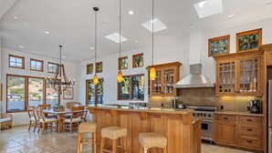 A spacious kitchen with a large island, wooden cabinets, and a view of the outdoors. - Light and Breezy Seadrift Lagoon Home w/ Hot Tub (Stinson Beach)